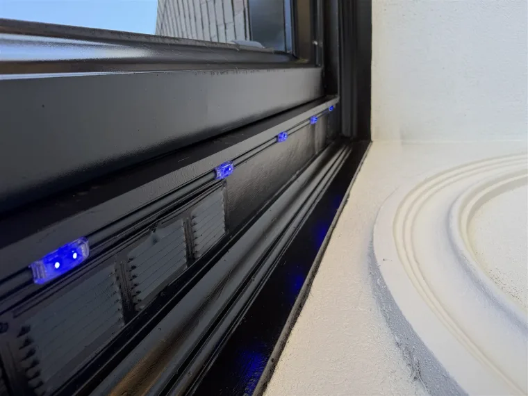 Black permanent lighting track blended into dark window trim