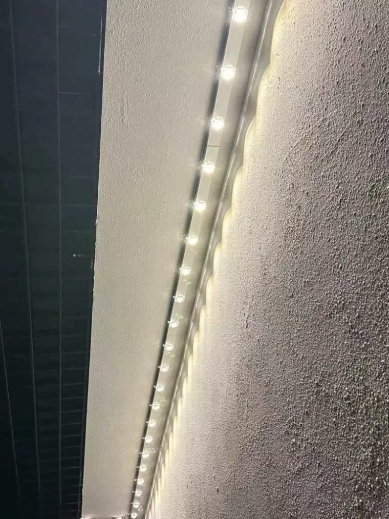 White permanent lighting track mounted close to the wall and soffit