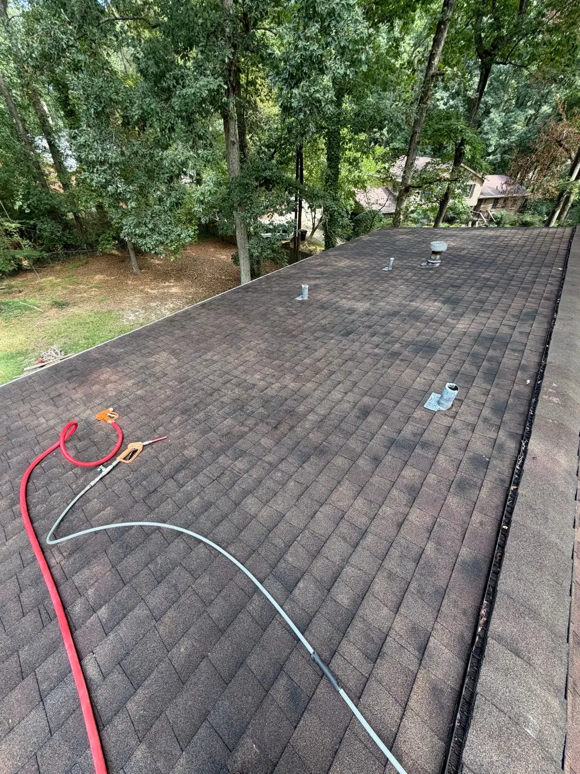 Shingle roof section with vents and dark streaking in Winder before washing