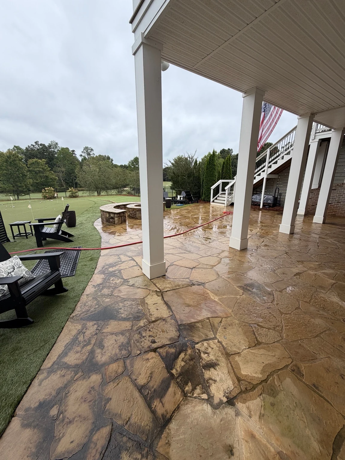 Flagstone beside an artificial turf putting green in Statham before cleaning