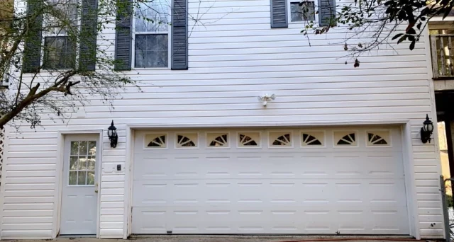 White two-story home and garage after washing with clean siding and a brighter garage door.